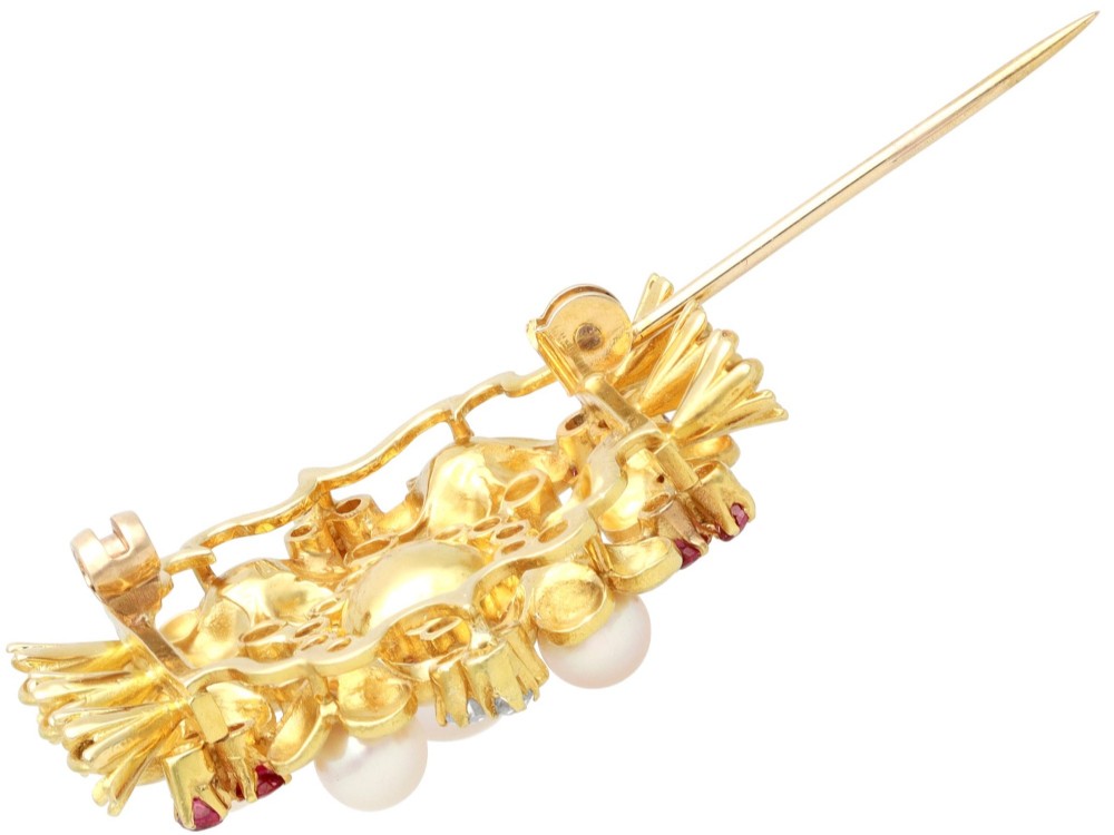 An 18ct yellow gold floral cluster brooch set with a central pearl surrounded by small rubies, outer cultured pearls, round diamonds, and red rubies. View XI