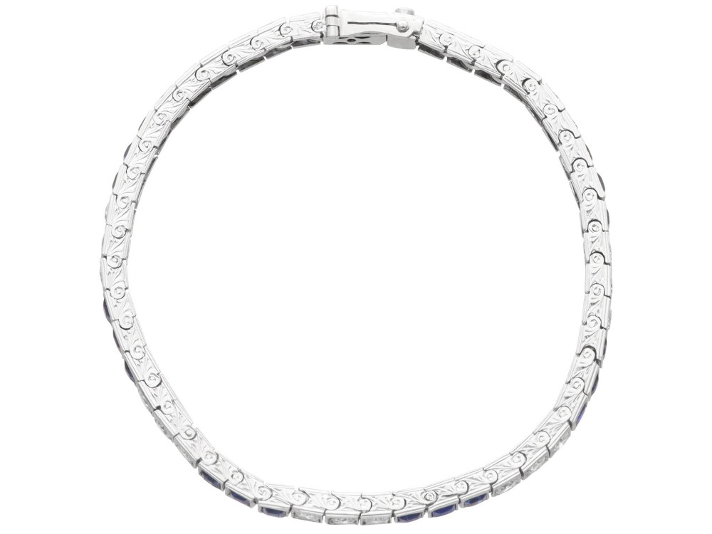 An Art Deco platinum line bracelet set with alternating square blue sapphires and round brilliant diamonds. View VII