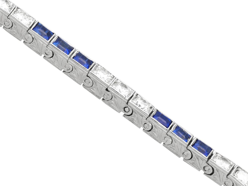An Art Deco platinum line bracelet set with alternating square blue sapphires and round brilliant diamonds. View VIII