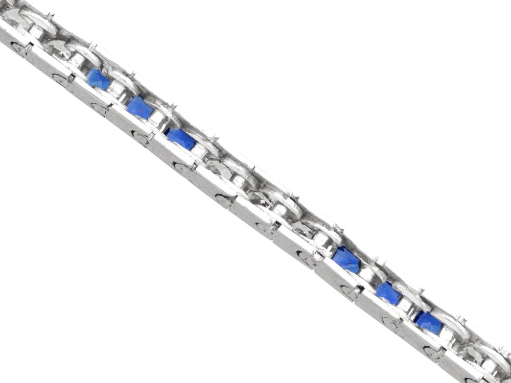 An Art Deco platinum line bracelet set with alternating square blue sapphires and round brilliant diamonds. View IX