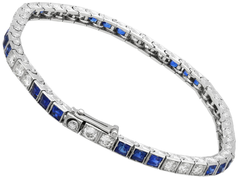 An Art Deco platinum line bracelet set with alternating square blue sapphires and round brilliant diamonds. View X