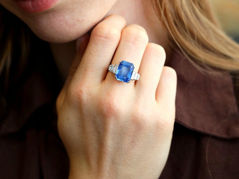 An emerald-cut blue sapphire ring set in platinum with stepped baguette diamond shoulders. View III