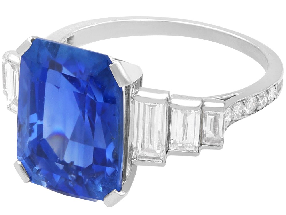 An emerald-cut blue sapphire ring set in platinum with stepped baguette diamond shoulders. View IV
