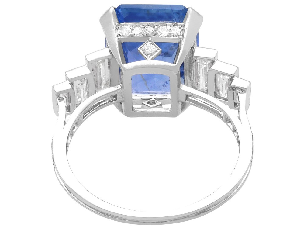 An emerald-cut blue sapphire ring set in platinum with stepped baguette diamond shoulders. View V