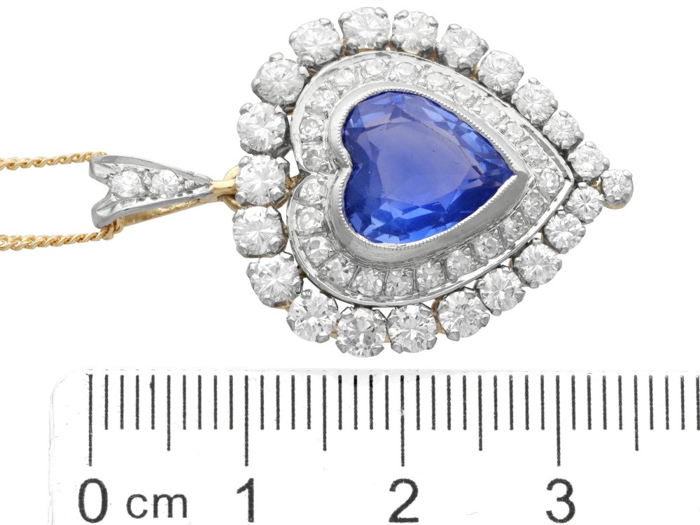 A heart-shaped 14ct yellow gold pendant featuring a central heart-cut Ceylon sapphire surrounded by a double halo of brilliant-cut diamonds. View VIII