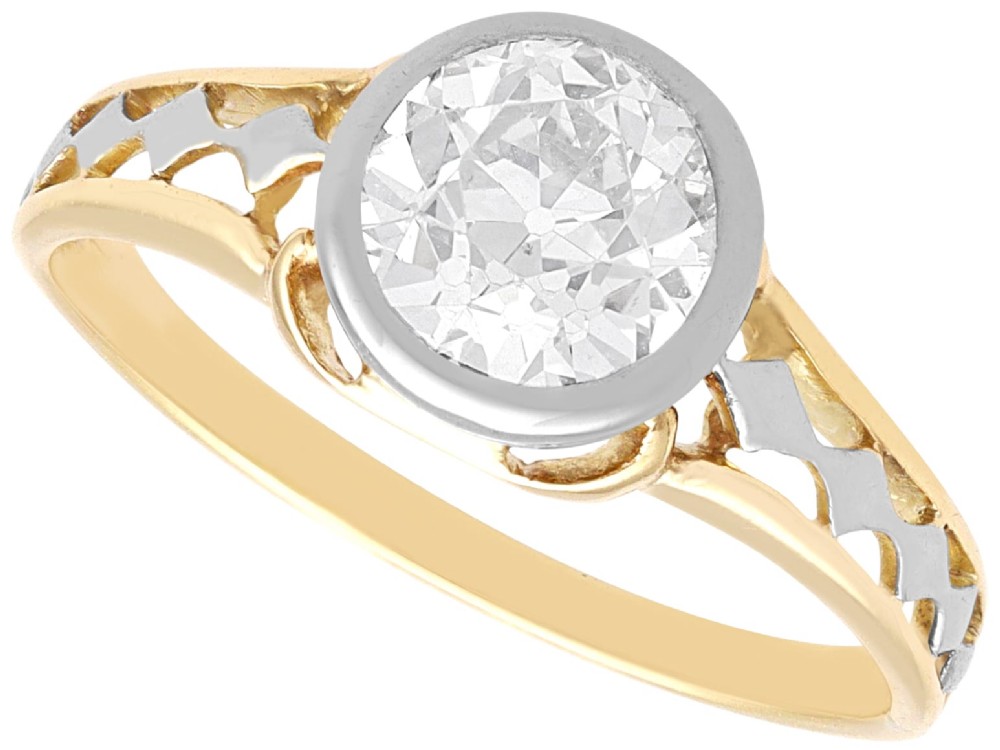 An antique 15ct yellow gold solitaire ring featuring a bezel-set round diamond with decorative openwork shoulders.