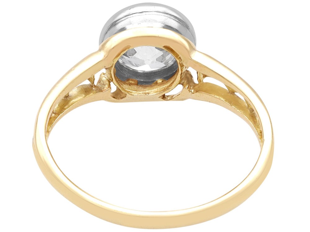 An antique 15ct yellow gold solitaire ring featuring a bezel-set round diamond with decorative openwork shoulders. View VII