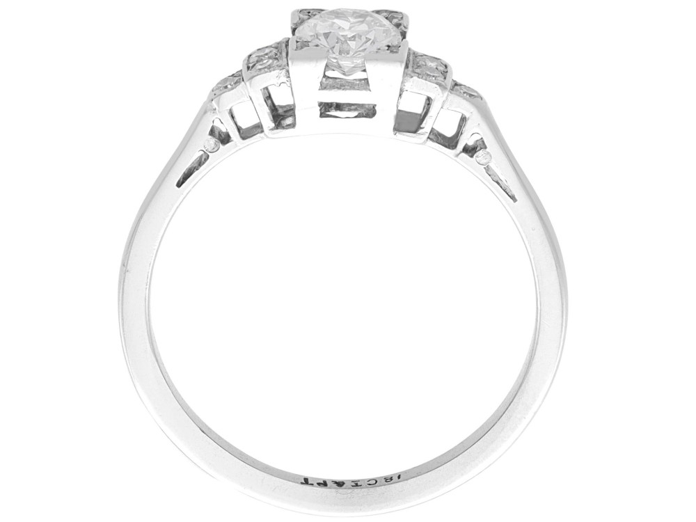 An Art Deco white gold and platinum ring featuring a central round diamond with stepped accent diamond shoulders. View V