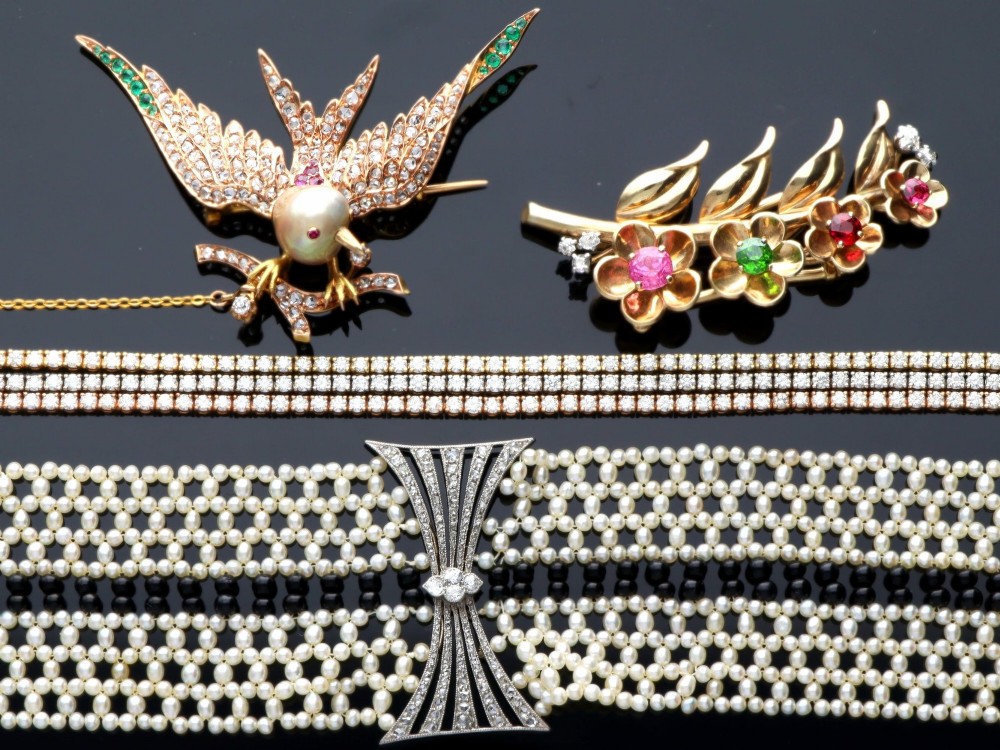 An Art Deco multi-strand pearl and black onyx cuff bracelet featuring a central geometric bow-shaped platinum mount set with diamonds. View VII