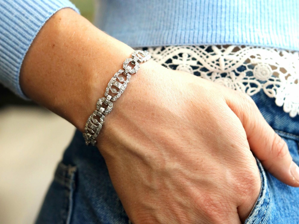 An Art Deco platinum bracelet featuring articulated geometric links set with brilliant-cut diamonds. View IV