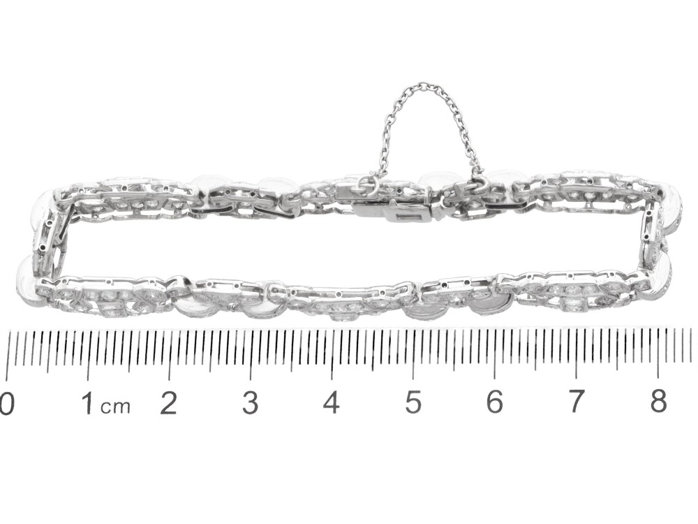 An Art Deco platinum bracelet featuring articulated geometric links set with brilliant-cut diamonds. View IX