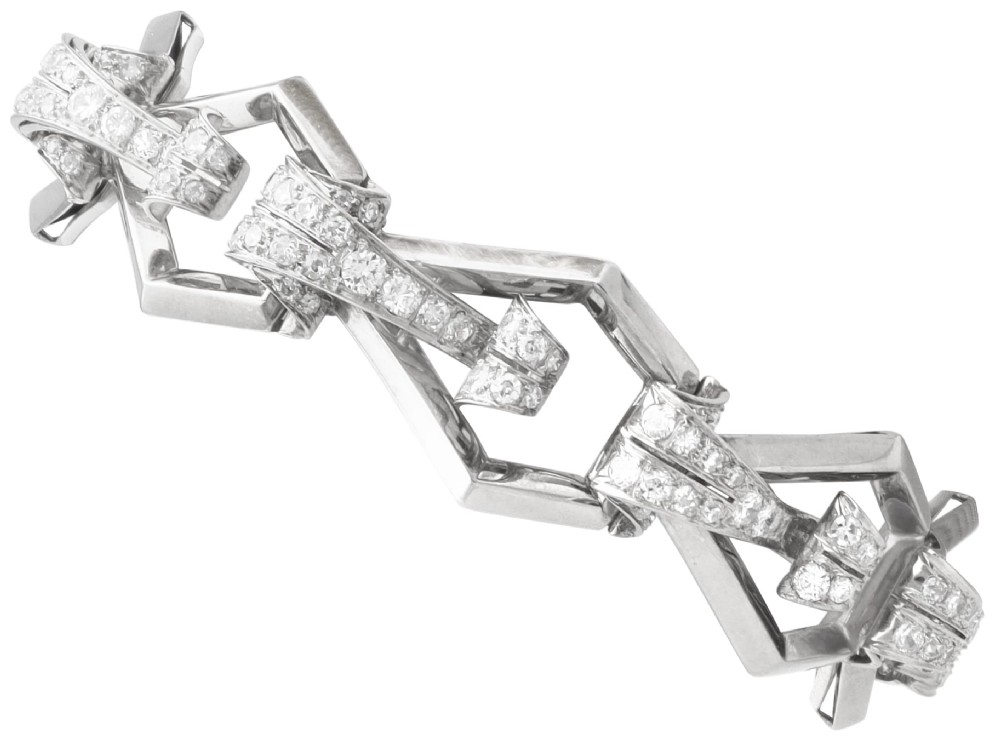 An Art Deco 18ct white gold link bracelet set with diamonds arranged in geometric openwork motifs.