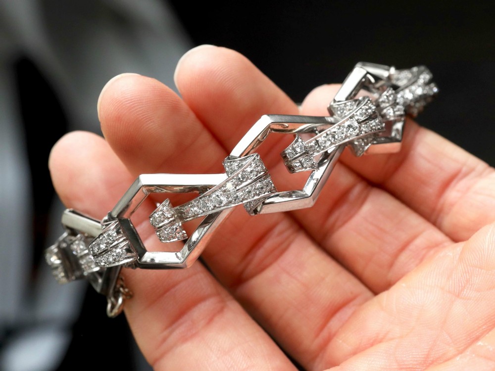 An Art Deco 18ct white gold link bracelet set with diamonds arranged in geometric openwork motifs. View V