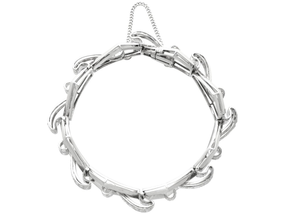 An Art Deco 18ct white gold link bracelet set with diamonds arranged in geometric openwork motifs. View VIII
