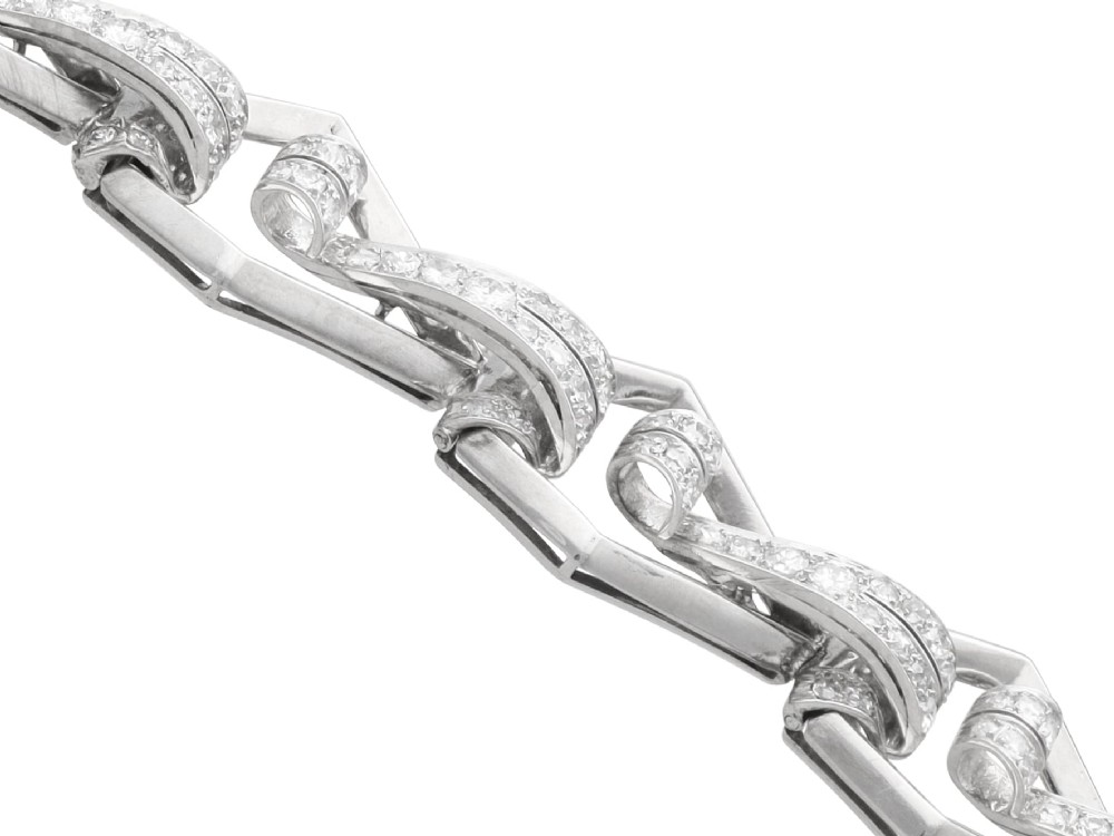 An Art Deco 18ct white gold link bracelet set with diamonds arranged in geometric openwork motifs. View IX