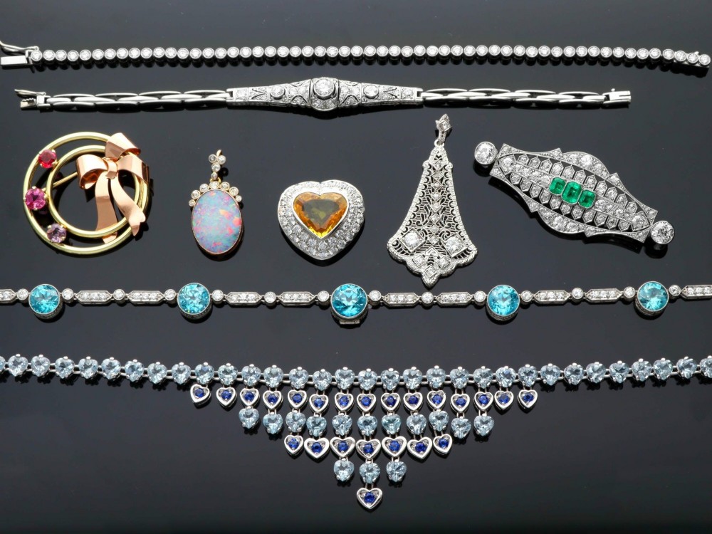 An Art Deco platinum chain necklace featuring five bezel-set round blue zircons separated by geometric diamond-set bar links. View VII