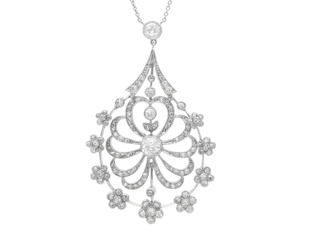 An antique Edwardian openwork platinum pendant set with diamonds in a teardrop silhouette with floral motifs, suspended from a fine chain.