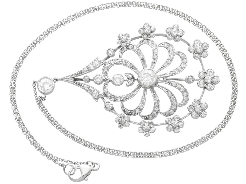An antique Edwardian openwork platinum pendant set with diamonds in a teardrop silhouette with floral motifs, suspended from a fine chain. View V