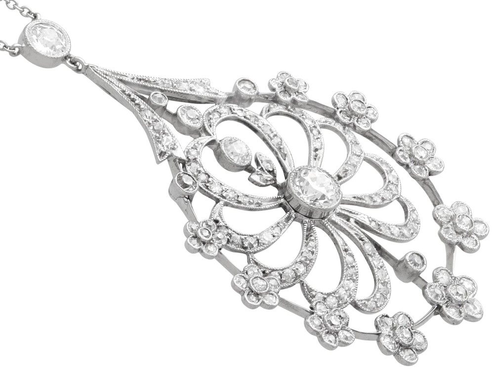 An antique Edwardian openwork platinum pendant set with diamonds in a teardrop silhouette with floral motifs, suspended from a fine chain. View VI