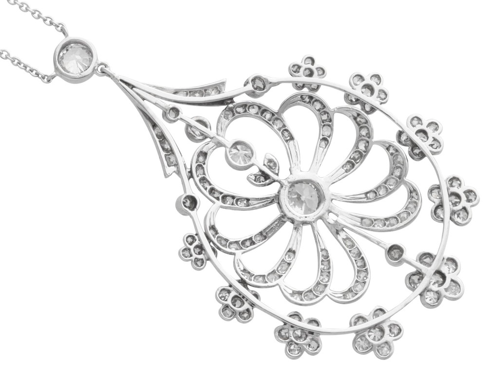 An antique Edwardian openwork platinum pendant set with diamonds in a teardrop silhouette with floral motifs, suspended from a fine chain. View VII
