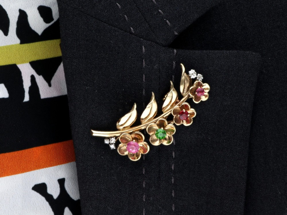 An antique 9ct yellow gold floral spray brooch featuring four carved flower heads set with colourful gemstones and diamond accents. View XIII