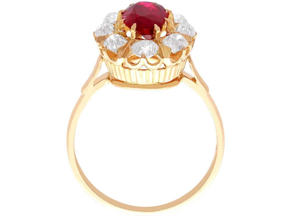 An 18ct rose gold cluster ring featuring a central oval red ruby surrounded by eight old cut diamonds set in individual claw settings. View IX