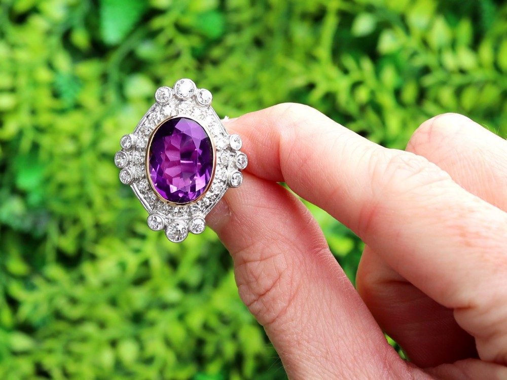An Art Deco ring featuring a central oval purple amethyst set in yellow gold, framed by a millegrain diamond halo. View II