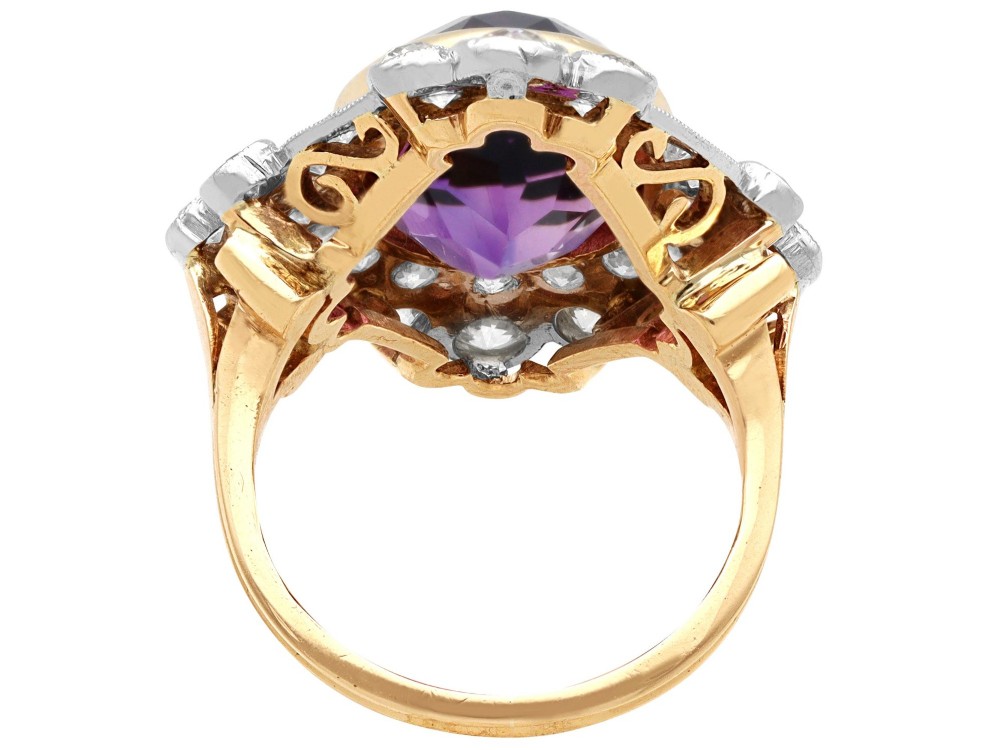 An Art Deco ring featuring a central oval purple amethyst set in yellow gold, framed by a millegrain diamond halo. View VII