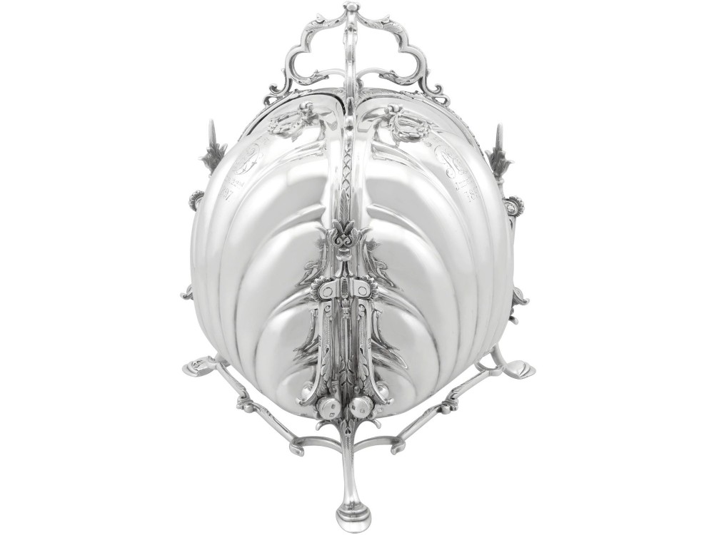 An antique Victorian sterling silver folding biscuit box featuring shell-form compartments, an ornate looped handle, and an engraved 1897 monogram. View II