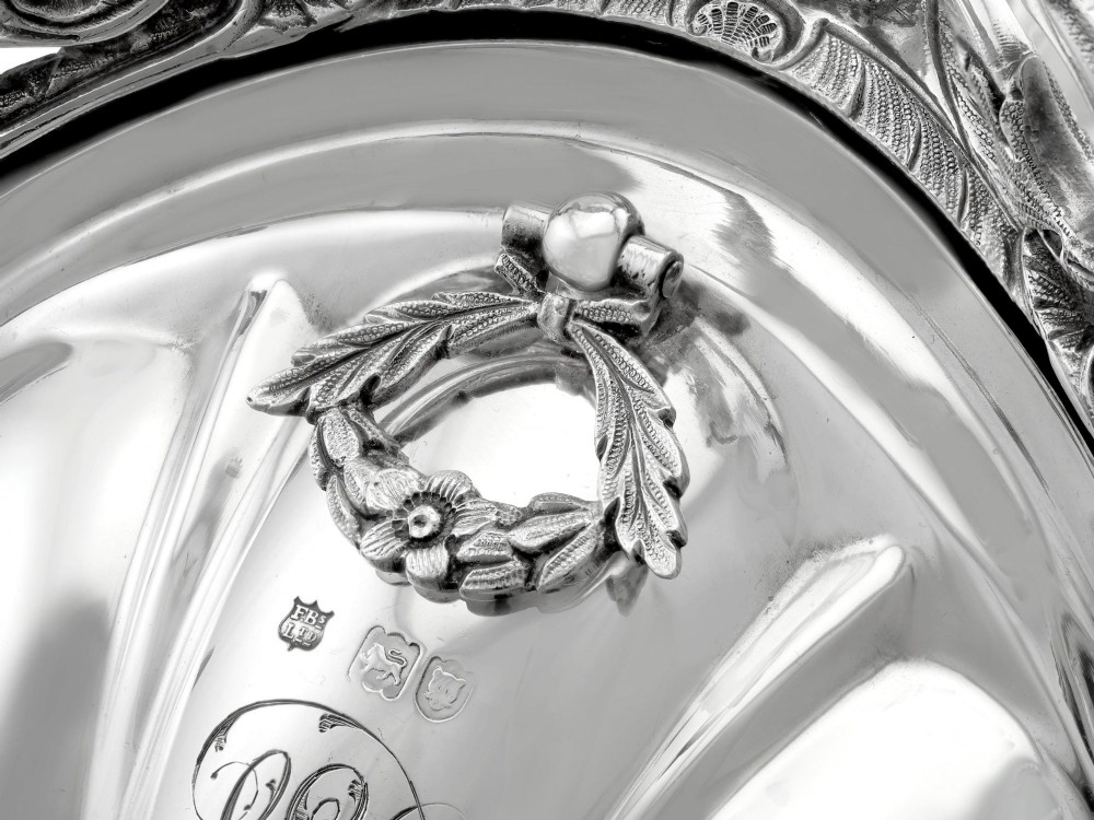 An antique Victorian sterling silver folding biscuit box featuring shell-form compartments, an ornate looped handle, and an engraved 1897 monogram. View XI