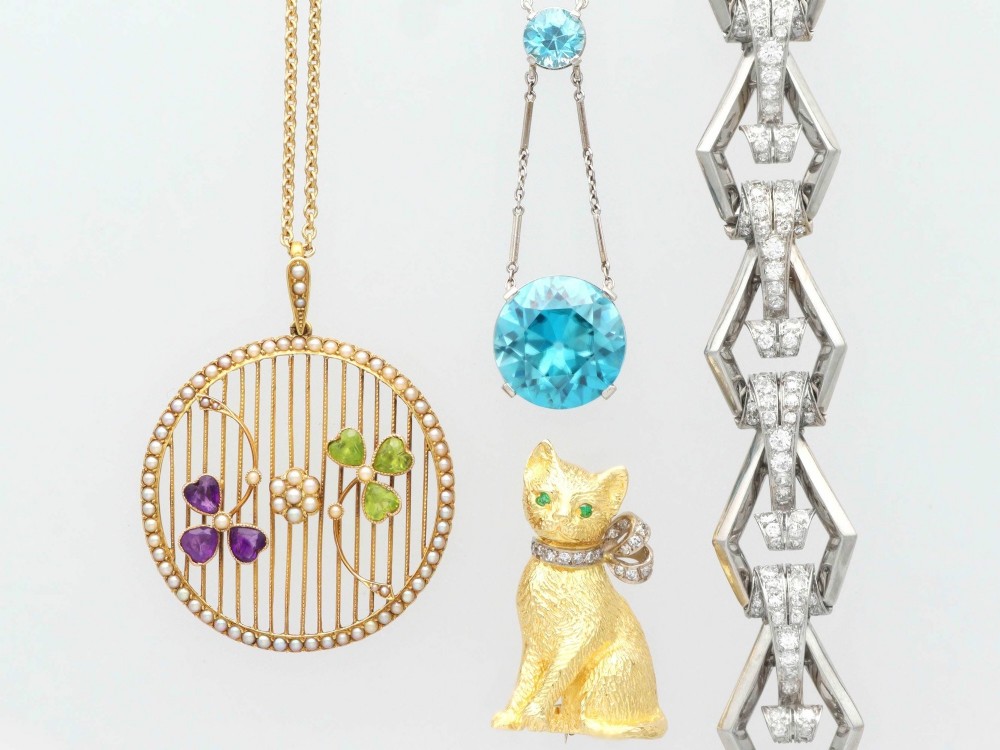 An Art Deco 18ct white gold drop pendant set with two round brilliant-cut bright blue zircon gemstones suspended on delicate bar links. View VI