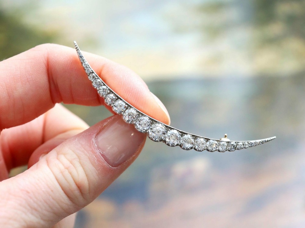 An antique crescent-shaped brooch set with a row of graduated diamonds mounted in gold and silver. View III
