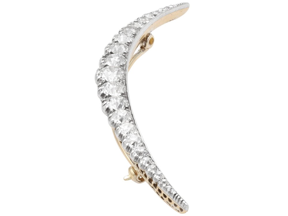 An antique crescent-shaped brooch set with a row of graduated diamonds mounted in gold and silver. View VIII