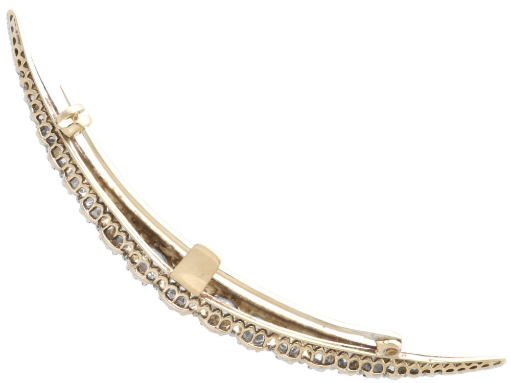 An antique crescent-shaped brooch set with a row of graduated diamonds mounted in gold and silver. View IX