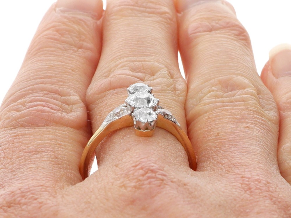 An antique 18ct yellow gold ring featuring five old-cut diamonds set in a geometric white metal arrangement. View XII