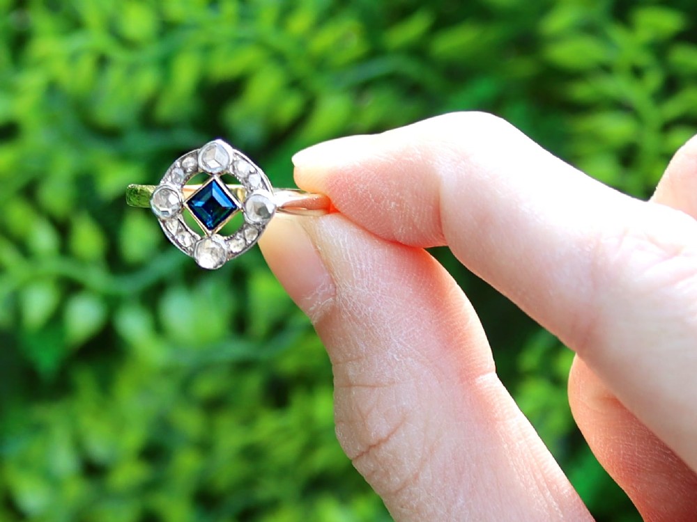 An 18ct yellow gold ring featuring a central square blue sapphire surrounded by an openwork diamond-set frame. View II