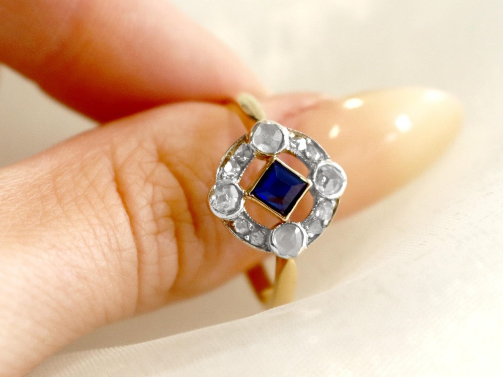 An 18ct yellow gold ring featuring a central square blue sapphire surrounded by an openwork diamond-set frame. View III