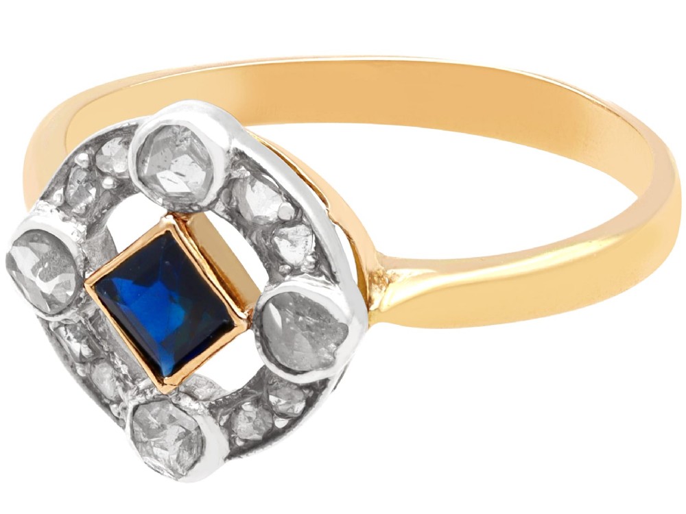 An 18ct yellow gold ring featuring a central square blue sapphire surrounded by an openwork diamond-set frame. View V