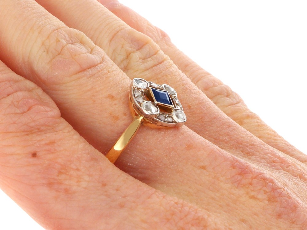 An 18ct yellow gold ring featuring a central square blue sapphire surrounded by an openwork diamond-set frame. View X