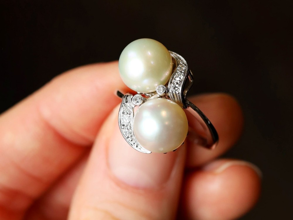A circa 1950 white gold crossover cocktail ring featuring two cultured pearls flanked by diamond-accented bypass shoulders. View III