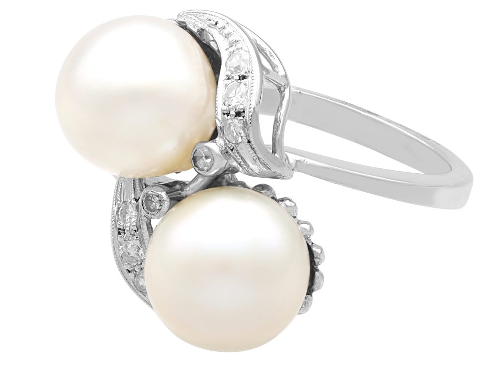 A circa 1950 white gold crossover cocktail ring featuring two cultured pearls flanked by diamond-accented bypass shoulders. View VII