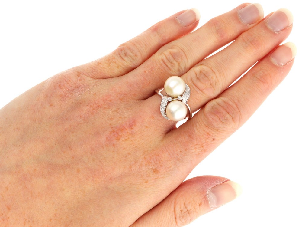 A circa 1950 white gold crossover cocktail ring featuring two cultured pearls flanked by diamond-accented bypass shoulders. View XI