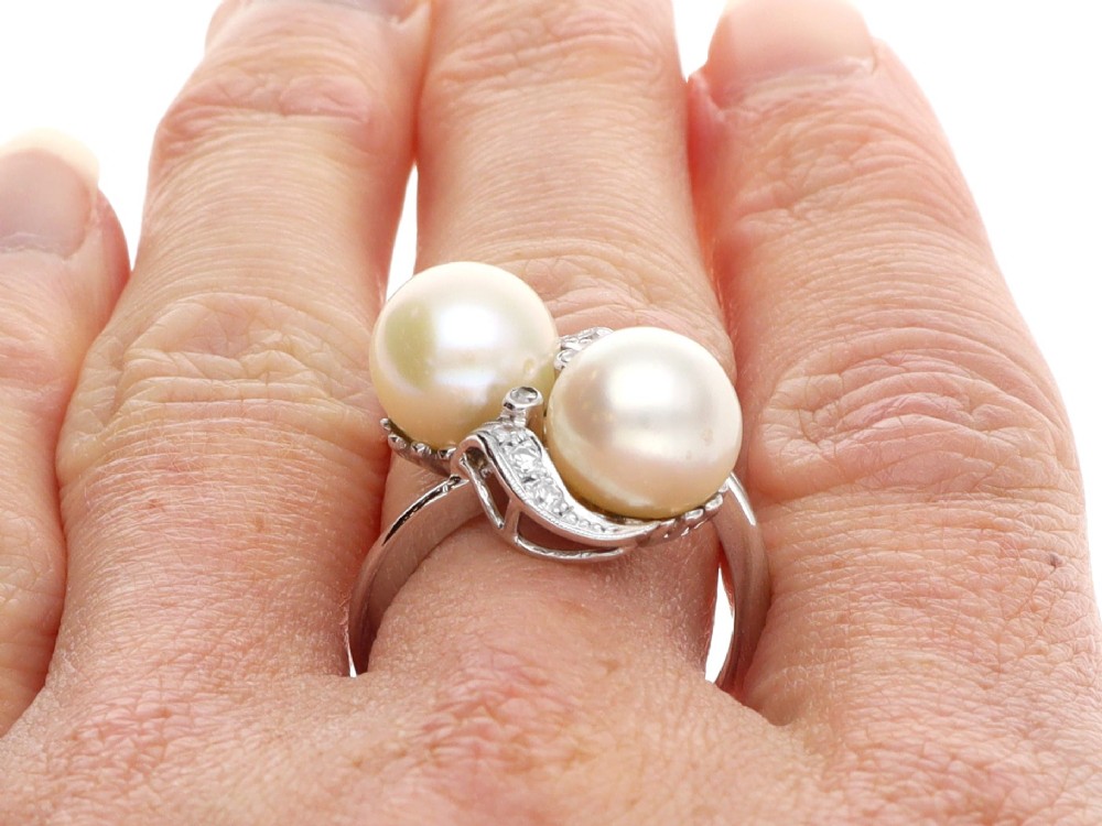 A circa 1950 white gold crossover cocktail ring featuring two cultured pearls flanked by diamond-accented bypass shoulders. View XIII
