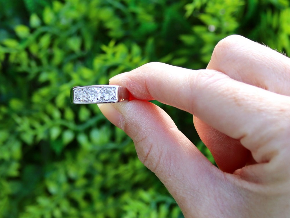 An 18ct white gold Art Deco trilogy ring featuring three round diamonds set horizontally across a wide band. View II