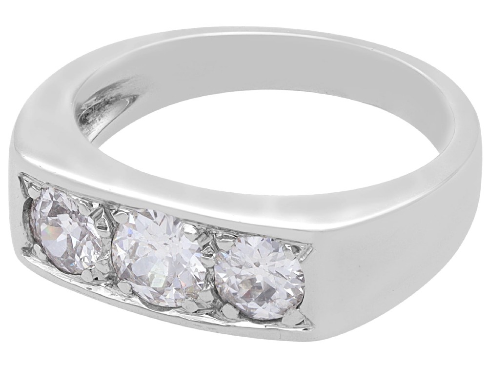 An 18ct white gold Art Deco trilogy ring featuring three round diamonds set horizontally across a wide band. View V