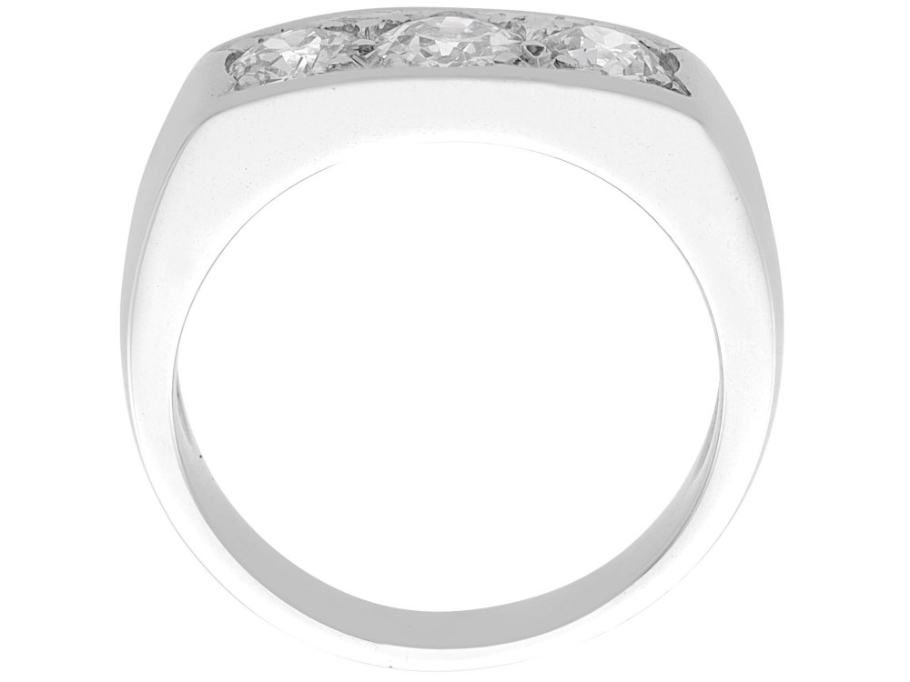 An 18ct white gold Art Deco trilogy ring featuring three round diamonds set horizontally across a wide band. View VII