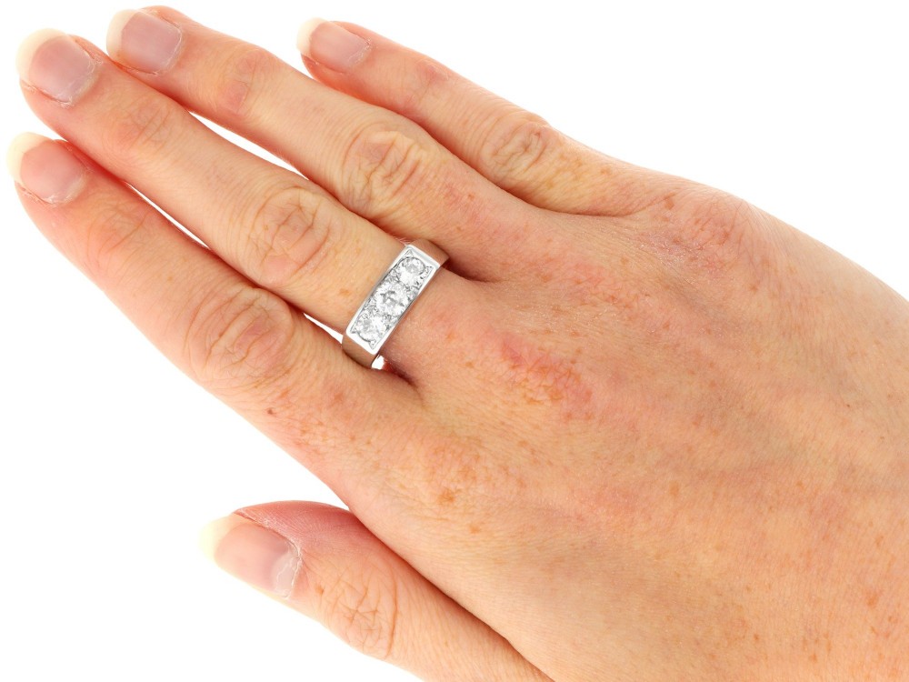 An 18ct white gold Art Deco trilogy ring featuring three round diamonds set horizontally across a wide band. View VIII