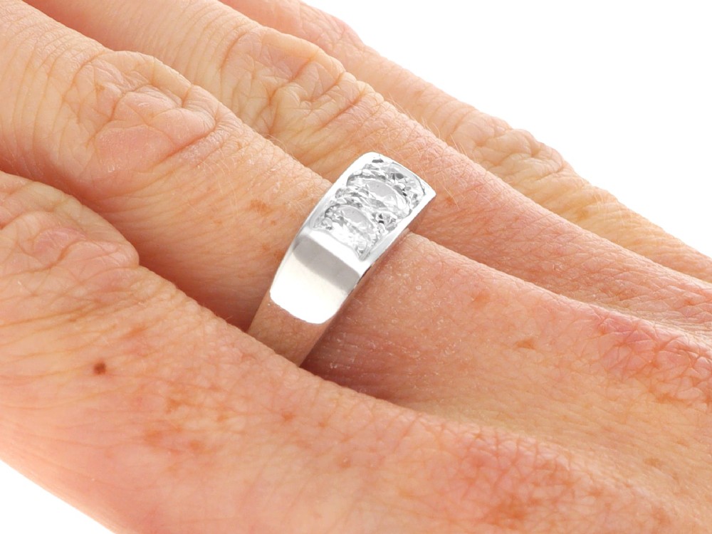 An 18ct white gold Art Deco trilogy ring featuring three round diamonds set horizontally across a wide band. View IX