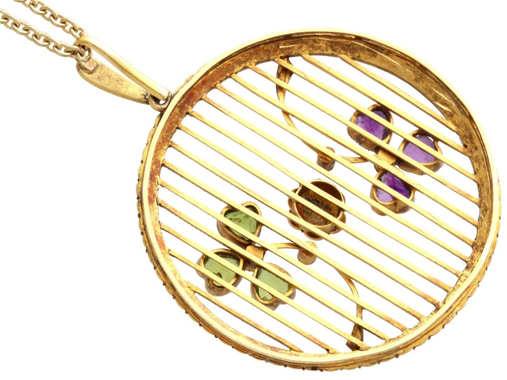 A circular 18ct yellow gold openwork pendant set with seed pearls along the outer rim, containing peridot and amethyst trefoil motifs and a central seed pearl cluster. View X
