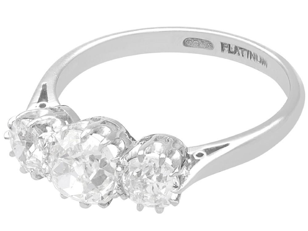 An Art Deco platinum ring set with three claw-set round diamonds positioned horizontally along the band. View VI